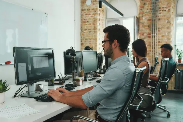 Employee using a web application on a computer in a shared workspace.